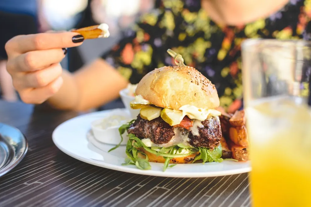 A guest eating a burger and fries