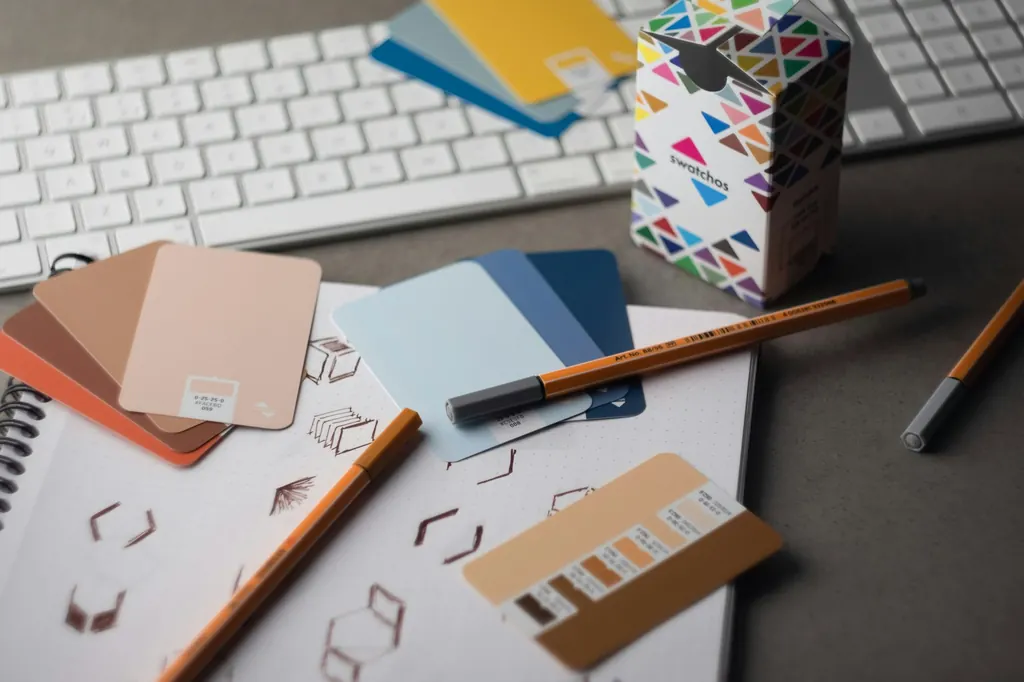 Color swatches, pencils, and logo sketches on a designer's desk