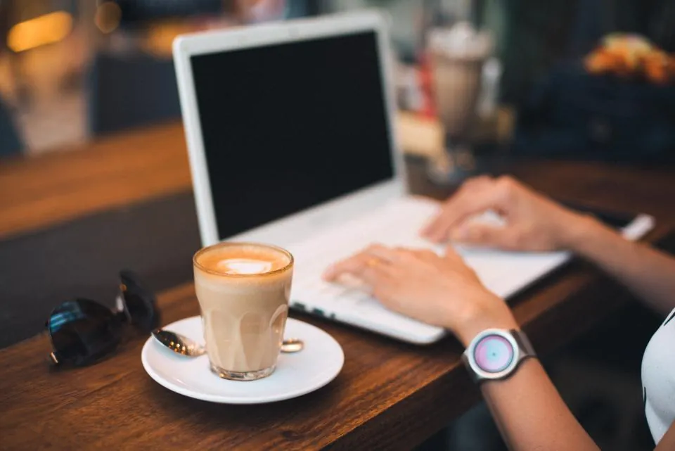 Laptop and a latte on a cafe table